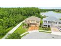 Beautiful aerial view of tan two-story home on a corner lot next to a walking path and lake at 3899 Mount Vernon Way, Kissimmee, FL 34741
