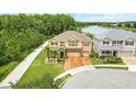 Beautiful aerial view of tan two-story home on a corner lot next to a walking path and lake at 3899 Mount Vernon Way, Kissimmee, FL 34741