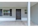 Welcoming front entrance with dark door, black shutters and a covered porch at 5627 Marvell Ave, Orlando, FL 32839