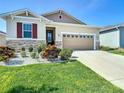 Attractive one-story home featuring a stone facade, neat landscaping, and an attached two-car garage at 591 Lake Smart Blvd, Winter Haven, FL 33881