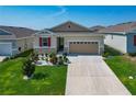 Inviting single-story home with a manicured lawn and long driveway leading to a two-car garage at 591 Lake Smart Blvd, Winter Haven, FL 33881