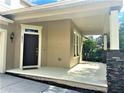 View of the house with the front door and front porch with beautiful stone columns at 6957 Northwich Dr, Windermere, FL 34786