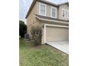 View of the exterior wall with the garage door and the AC on the grassy lot at 6957 Northwich Dr, Windermere, FL 34786