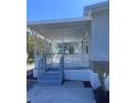 A covered porch with white lattice railings offers a charming outdoor relaxation spot at 710 Whispering Pines Dr, Auburndale, FL 33823