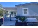 Charming single story home featuring a covered porch, complemented by fresh landscaping and healthy palm trees at 710 Whispering Pines Dr, Auburndale, FL 33823