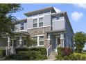Beautiful townhome with gray siding, stone accents, and a well-maintained front yard at 8042 Glenlloyd Ave, Winter Garden, FL 34787