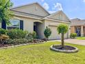 Charming home featuring a well-maintained lawn with landscaped garden beds and a two-car garage at 810 Jefferson Blvd, Haines City, FL 33844