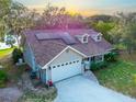 Lovely home featuring solar panels, manicured lawn, garage and beautiful sunset background at 822 S Breen Rd, Lake Wales, FL 33898