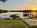 Picturesque sunset view over the tranquil lake, complemented by a private dock and lush green landscape at 822 S Breen Rd, Lake Wales, FL 33898