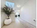 Bright foyer with tiled floors, decorative tree, and chandelier lighting creates a welcoming entrance at 895 Overpool Ave, Davenport, FL 33896