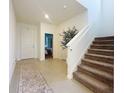 Inviting foyer with tiled floors, staircase, and view into a bedroom at 895 Overpool Ave, Davenport, FL 33896