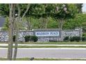 Stone entrance sign to the Madison Place community with flowering trees in background at 1113 Merrill St, Davenport, FL 33837