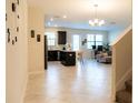 Open-concept living space with tile flooring and modern finishes that connects the kitchen to the living area at 11378 Whistling Pine Way, Orlando, FL 32832