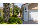 The house number stands out next to the garage and the red brick driveway in a lush tropical environment at 12041 Kajetan Ln, Orlando, FL 32827