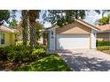 Garage with brick driveway, green grass, and vibrant landscaping that adds curb appeal at 12041 Kajetan Ln, Orlando, FL 32827