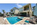 Large swimming pool and spa with a basketball hoop, chairs, and manicured hedges in the backyard at 1228 Castle Pines Ct, Reunion, FL 34747