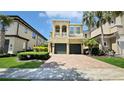 Stunning two-story home with a well-manicured lawn, two-car garage, and beautiful architectural details at 1228 Castle Pines Ct, Reunion, FL 34747