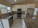 Modern kitchen with stainless steel appliances, granite countertops, and ample cabinet space at 13940 Corrine Key Pl, Orlando, FL 32824