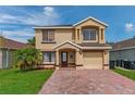 Charming two-story home with a brick driveway, lawn, and neutral exterior paint at 1425 Carey Glen Cir, Orlando, FL 32824