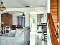 Open concept living area featuring a comfortable sofa, wood staircase, and easy access to the kitchen at 1425 Carey Glen Cir, Orlando, FL 32824