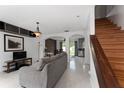 Bright living room with gray sofa, white tile floors, stairs, and stylish decor at 1425 Carey Glen Cir, Orlando, FL 32824