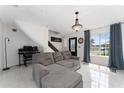 Bright living room with gray sofa, white tile floors, and large window at 1425 Carey Glen Cir, Orlando, FL 32824
