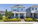 Beautiful two-story home with a covered porch, decorative columns, and lush landscaping in a residential area at 14309 Lanikai Beach Dr, Orlando, FL 32827
