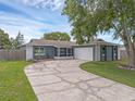 Charming single-story home with a cracked circular driveway, lush lawn, and a two-car garage at 1436 Nolton Way, Orlando, FL 32822