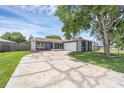 Charming single-story home with a cracked circular driveway, lush lawn, and a two-car garage at 1436 Nolton Way, Orlando, FL 32822