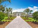 Stunning two-story home featuring a grand entrance, lush landscaping, and a beautiful grey paver driveway at 15121 Pendio Dr, Montverde, FL 34756