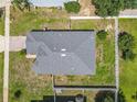 Aerial view of a home showcasing the roof, backyard, and fencing surrounded by green lawns and mature trees at 15341 Groose Point Ln, Clermont, FL 34714