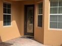 Front door is centered between two windows and offers a brick paved entrance and is decorated with a patterned front door at 2495 Palm Tree Dr, Kissimmee, FL 34759