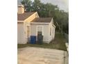 Backyard view of a single-story home with trees, a small yard, and a trash receptacle at 380 S Echo Dr, Lake Alfred, FL 33850