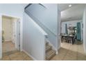 Bright entryway featuring tile floors, staircase, and a glimpse into the dining area at 4875 Clock Tower Dr, Kissimmee, FL 34746