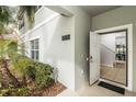 Inviting front entrance with open door, manicured landscape, and view to entry way at 4875 Clock Tower Dr, Kissimmee, FL 34746