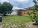 A spacious backyard featuring a well-maintained lawn and perimeter fence for privacy, and mature trees at 513 Ronshelle Ave, Haines City, FL 33844
