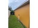 Side yard showing grass and the side of the home along with a white fence in the background at 513 Ronshelle Ave, Haines City, FL 33844