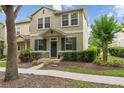 Inviting townhome showcases stone accents, verdant landscaping, and a welcoming green front door at 7144 Five Oaks Dr, Harmony, FL 34773