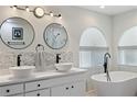 Elegant bathroom with double vessel sinks, freestanding tub, and modern fixtures, creating a spa-like experience at 7222 Stanford Dr, Lakeland, FL 33809