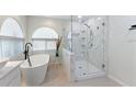 Updated bathroom with a sleek glass-enclosed shower featuring marble accents and a modern soaking tub at 7222 Stanford Dr, Lakeland, FL 33809