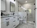 Beautifully renovated bathroom featuring white cabinets, black hardware, and a luxurious marble-tiled shower at 814 Gator Ln, Deltona, FL 32738