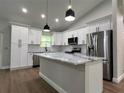 Modern kitchen with white cabinets, marble countertops, stainless steel appliances, and center island at 814 Gator Ln, Deltona, FL 32738