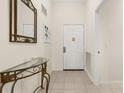 Welcoming foyer featuring decorative mirror, console table, and neutral tile flooring, perfect for a stylish entrance at 9055 Treasure Trove Ln # 409, Kissimmee, FL 34747