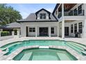View of the backyard pool and spa with elegant patio and columns at 9799 Covent Garden Dr, Orlando, FL 32827