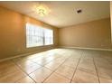 Bright living room with natural light from large window, tile flooring and neutral paint at 1001 Plantation Dr # E1, Kissimmee, FL 34741