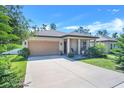 Inviting home exterior with a well-maintained lawn, neutral paint, attached two-car garage, and covered porch at 1096 Roberta Rd, Lake Wales, FL 33853