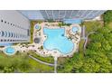 Overhead view of community pool with unique design surrounded by lush landscaping and patio seating areas at 13415 Blue Heron Beach Dr # 401, Orlando, FL 32821