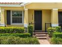 Inviting front entrance with a brick walkway, manicured bushes, and a black front door with sidelight at 14344 Swanley St, Orlando, FL 32832