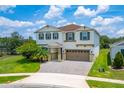 Two-story home featuring neutral paint, green shutters, a brick paved driveway and well-maintained landscaping at 14421 Ward Rd, Orlando, FL 32824