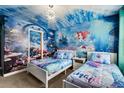 Fun, themed bedroom featuring custom undersea mural and decor with two white twin beds at 1456 Belle Terre Rd, Davenport, FL 33896